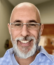 Bearded man in blue shirt smiling