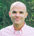 Smiling man wearing a pink shirt