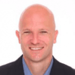 Man in blazer smiles warmly