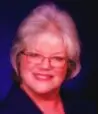 Smiling woman with glasses and white hair