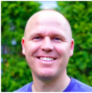 Smiling person outdoors with green background