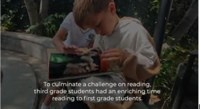 Third grade students reading to first grade students at Eton School