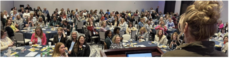 Jerri Kemble presenting to a large group of women