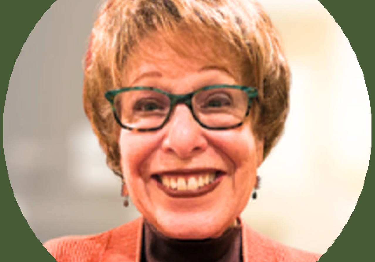 Smiling woman with glasses and short hair.