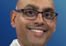 Professional man with glasses against blue background