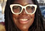 Smiling individual wearing distinctive white glasses