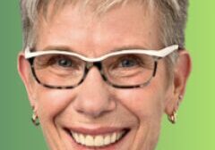 Smiling person with short hair and glasses