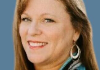 Woman with earrings against blue background.
