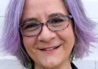 Woman with purple hair and glasses