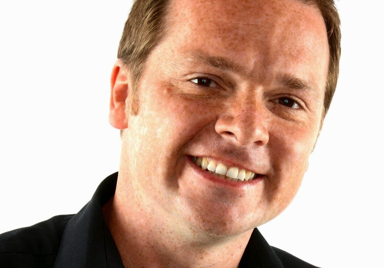 Smiling man in black shirt headshot