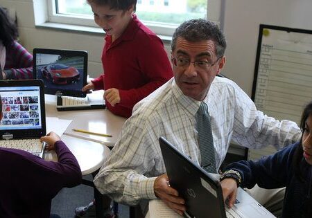 Students and teacher using laptops in classroom