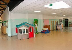 Spacious preschool common area with playhouses