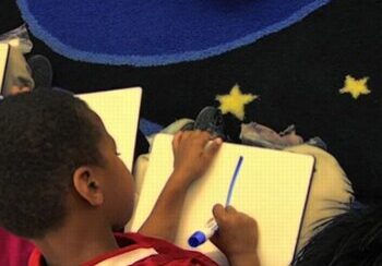Kid holding a marker and whiteboard