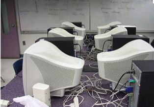 Tangled cables beneath white CRT monitors