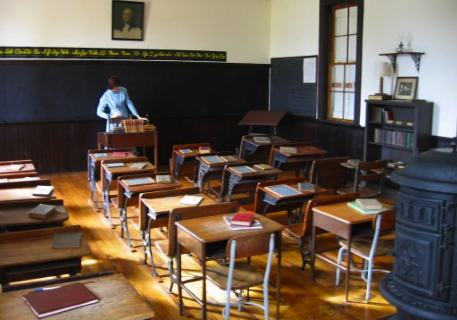 One room schoolroom with teacher and stove