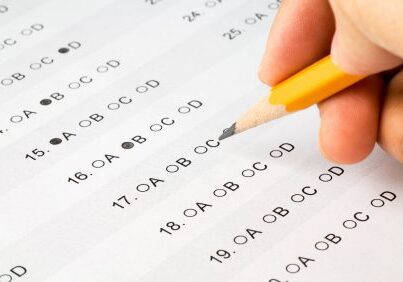 Hand filling multiple-choice answer sheet